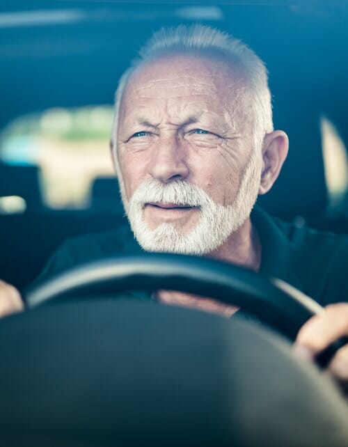 Senior man having bad eye sight and making effort to see the road.