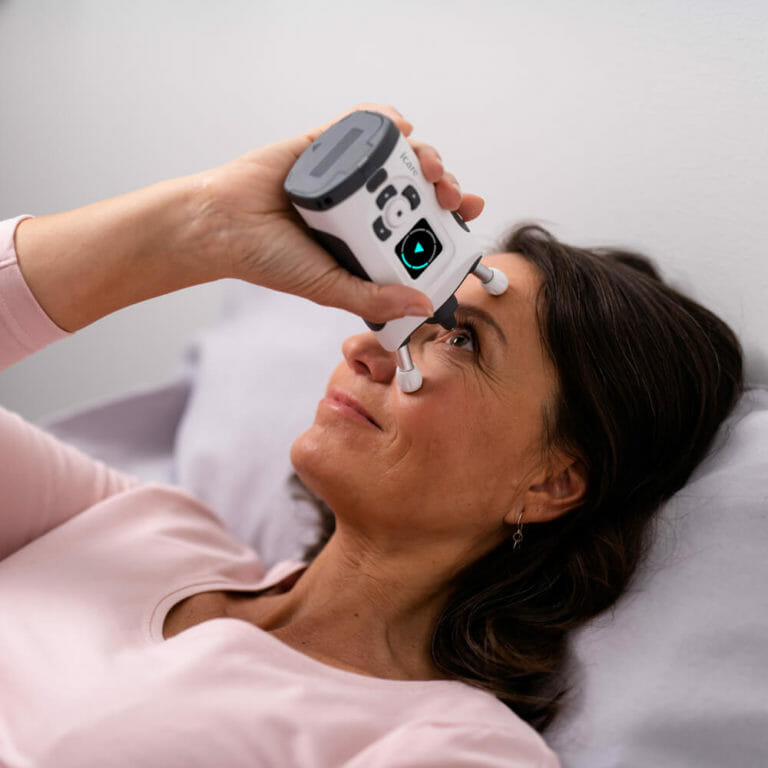 Glaucoma patient using the iCare HOME2 lying down to measure their IOP